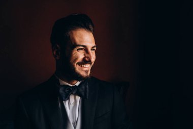 Zarif takım elbiseli ve papyonlu yakışıklı genç damat portresi.     