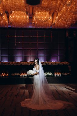 Beyaz gelinlik içindeki güzel gelinin portresi.              