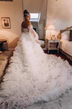 Lüks içinde poz veren beyaz gelinlik içindeki güzel gelinin portresi.