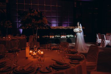 Restoranın arka planında çiçekler olan beyaz elbiseli güzel bir gelin..    