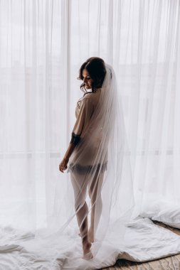 İpek bornozlu ve peçeli güzel gelin sabah evde.   