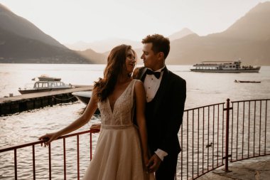 Genç ve güzel bir çift gölün arka planında poz veriyor. 