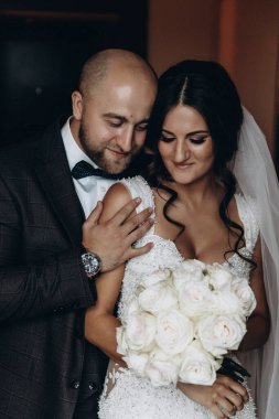 Genç, güzel gelin ve damat içeride poz veriyor.