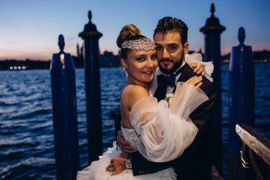 Güzel mutlu gelin ve damat Venedik 'te rıhtımda sarılıyor.      