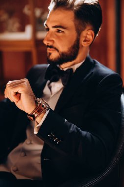 Şık giyinmiş zarif genç adam ve saat.