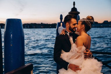 Güzel mutlu gelin ve damat Venedik 'te rıhtımda sarılıyor.      
