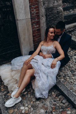 Mutlu gelin ve damat eski şehrin merdivenlerinde oturuyor.