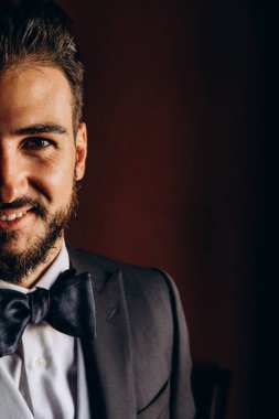 Zarif takım elbiseli ve papyonlu yakışıklı genç damat portresi.     
