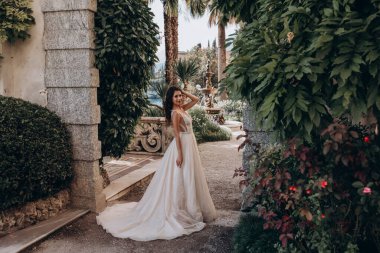 Beyaz gelinlikli güzel gelin eski kasaba caddesinde poz veriyor.                