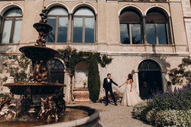 Güzel, genç bir çift eski evin önünde poz veriyor..