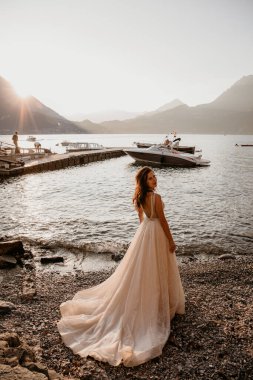 Gelin gün batımında denizin ve dağların arkasında 