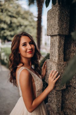 Beyaz gelinlikli güzel gelin eski kasaba caddesinde poz veriyor.                