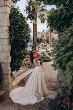 Beyaz gelinlikli güzel gelin eski kasaba caddesinde poz veriyor.                