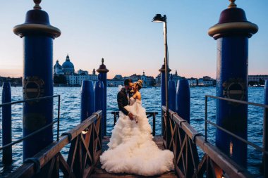 Güzel mutlu gelin ve damat Venedik 'te rıhtımda sarılıyor.      