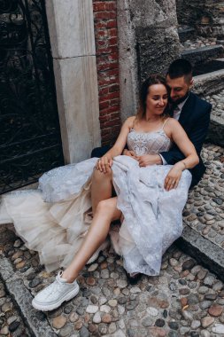 Mutlu çift merdivenlerde birbirine sarılıyor ve oturuyor.