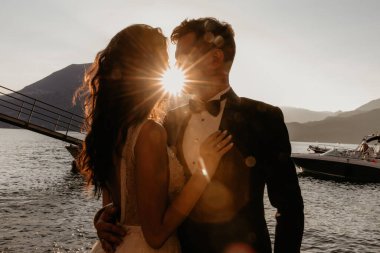 Güzel yeni evliler deniz kenarında gün batımında poz veriyorlar. 