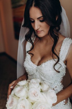 Beyaz gelinlik içindeki güzel gelinin portresi.              