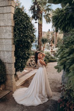 Beyaz gelinlikli güzel gelin eski kasaba caddesinde poz veriyor.                