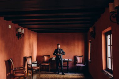 Zarif takım elbiseli ve papyonlu yakışıklı genç damat portresi.     