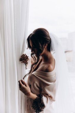 İpek bornozlu ve peçeli güzel gelin sabah evde.   