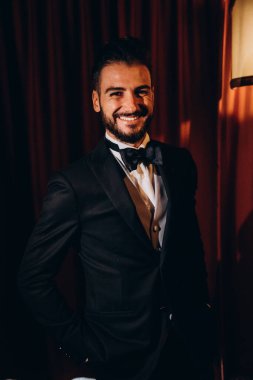 Zarif takım elbiseli ve papyonlu yakışıklı genç damat portresi.     