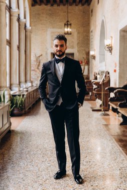 Yakışıklı genç damadın portresi. Zarif iç ceplerinde elleri ile poz veriyor.