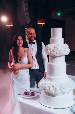 Mutlu gelin ve damat restoranda pasta kesiyor. 