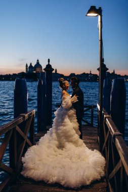 Güzel mutlu gelin ve damat Venedik 'te rıhtımda sarılıyor.      