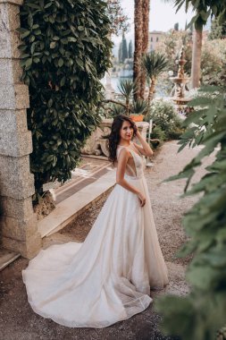 Beyaz gelinlikli güzel gelin eski kasaba caddesinde poz veriyor.                