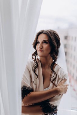 İpek bornozlu ve peçeli güzel gelin sabah evde.   