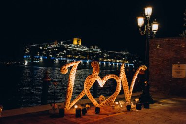 Venedik, İtalya 'da gece vakti kalp şeklinde güllerden ve mumlardan yapılmış güzel bir düğün süsü..