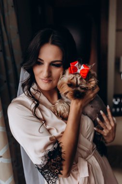 Güzel, genç bir gelin ve evde küçük sevimli bir köpek var.       