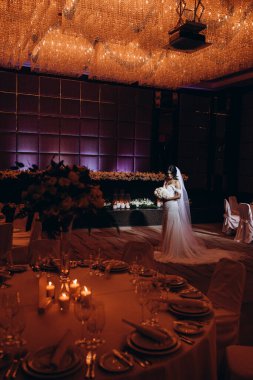 Restoranın arka planında çiçekler olan beyaz elbiseli güzel bir gelin..    