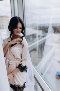 İpek bornozlu ve peçeli güzel gelin sabah evde.   