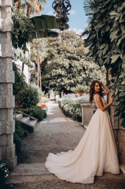 Beyaz gelinlikli güzel gelin eski kasaba caddesinde poz veriyor.                