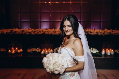 Beyaz gelinlik içindeki güzel gelinin portresi.              