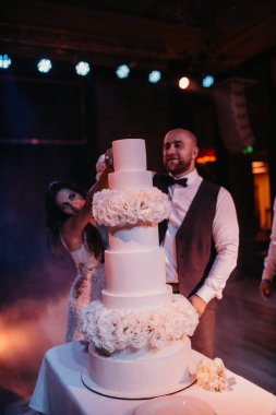 Mutlu gelin ve damat restoranda pasta kesiyor. 