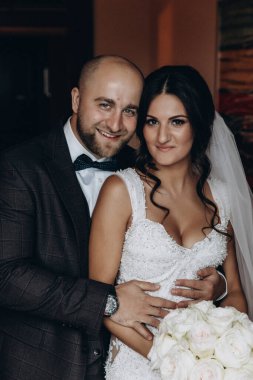 Beyaz gelinlik içinde güzel gelin ve takım elbiseli yakışıklı damat.