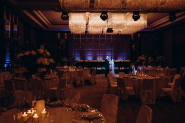 Gelin ve damat düğün salonunda servis masalarıyla 