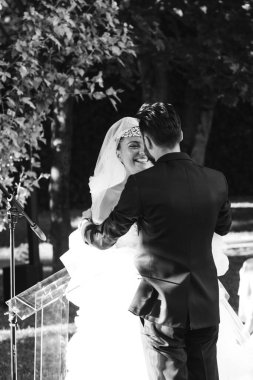 Düğün çifti sarılıyor ve öpüşüyorlar. 