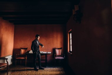 Genç adam odada duruyor.