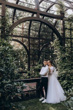 Gelin ve damat parkta fotoşoplama yapıyorlar.