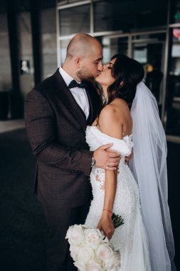 Bulanık binalarda öpüşen mutlu yeni evliler. 