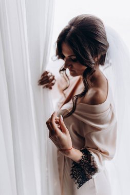 Sabahları beyaz peçeli ve bornozlu gelin içeride poz veriyor.