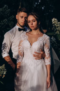 Güzel gelin ve damat düğün günü dışarıda poz veriyor.