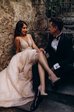 Eski kasabadaki merdivenlerde poz veren mutlu genç bir çiftin portresi.                           