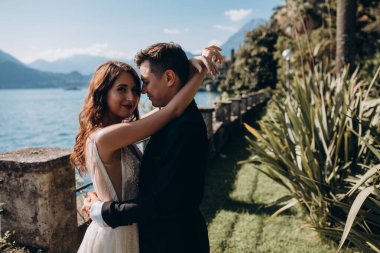 Güzel, mutlu, genç bir çift göl kenarında kucaklaşıyorlar.              