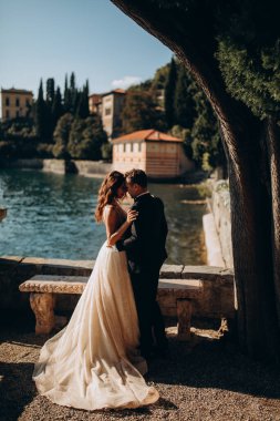 Birbirlerine aşık genç bir çift göl kıyısında kucaklaşıyorlar..