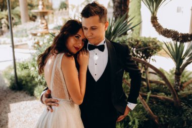 Güzel mutlu gelin ve damat parkta kucaklaşıyorlar.      