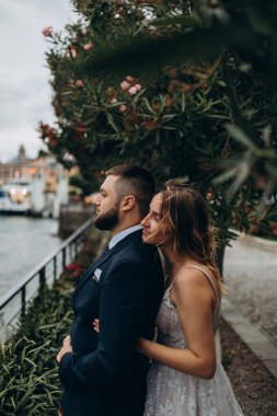 Deniz ve şehrin arka planında poz veren güzel gelin ve damat.